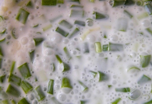 1. Этап. Пирог с лососем, зеленью и овощами: Для заливки яйца немного взбейте со сливками и молоком, добавьте нарезанный зеленый лук, немного посолите, поперчите и перемешайте.