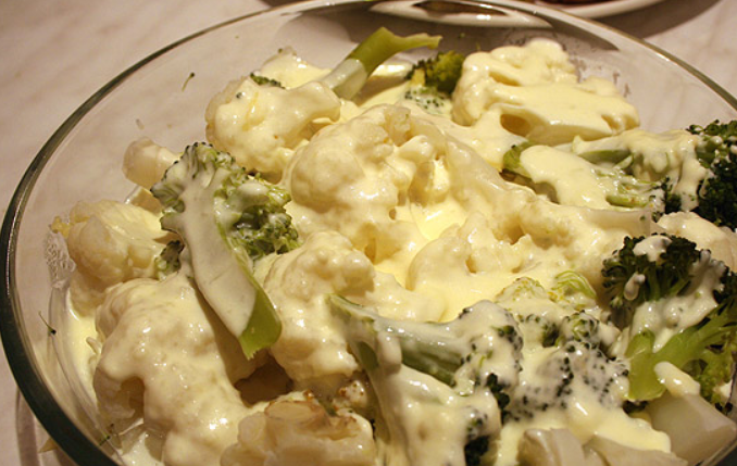 1. Этап. Цветная капуста, запеченная под соусом: Складываем овощи в форму для запекания и заливаем их молочным соусом. Сливочный сыр трем на крупной терке, присыпаем им овощи. Запекаем блюдо в духовке до золотистой корочки. Температура 220 градусов.