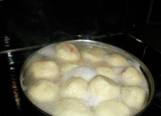 1. Этап. Творожные кнедлики с клубникой: 6. В кастрюлю налейте воды, поставьте на сильный огонь, и дождитесь пока вскипит. После закипания аккуратно добавляйте кнедлики в воду. Принцип готовности творожных кнедликов такой же как у пельменей: необходимо варить примерно 10-15 минут в кипящей воде, пока не всплывут.