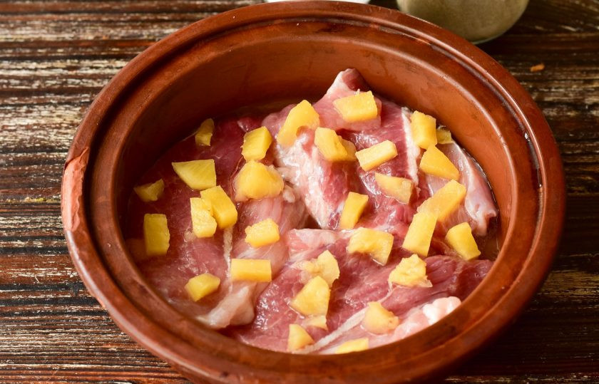 1. Этап. Свинина с ананасами и грибами в духовке: Посолите мясо и поперчите с двух сторон. Сверху выложите консервированные ананасы. Если кусочки крупные, тогда обязательно их нарежьте на более мелкие.