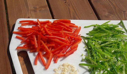 1. Этап. Китайский салат с молодым зеленым горошком: Горошек порезать тонкой полоской. У перца убрать семена, так же порезать тонкой длинной соломкой. Чеснок очистить, мелко порубить.