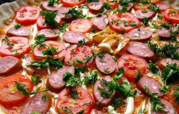 1. Этап. Пицца с копчёной колбаской: Петрушку и укроп помойте, измельчите и выложите сверху на ингредиенты.