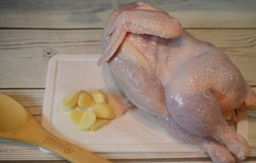 1. Этап. Домашняя курица, фаршированная яблоками и айвой: 1. Курицу помойте и обсушите. Чеснок нарежьте пластинками.