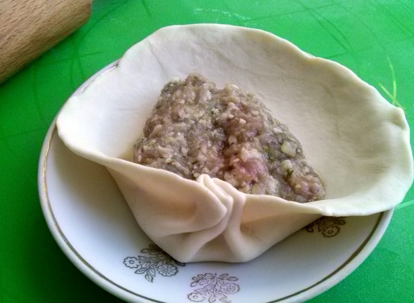 1. Этап. Хинкали (классический рецепт): Для удобства формовки хинкали поместите лепешку на блюдце. В центр лепешки положите 1-1,5 ст. л. фарша, соберите тесто складками по кругу. По традиции в хинкали должно быть не менее 19 складок.