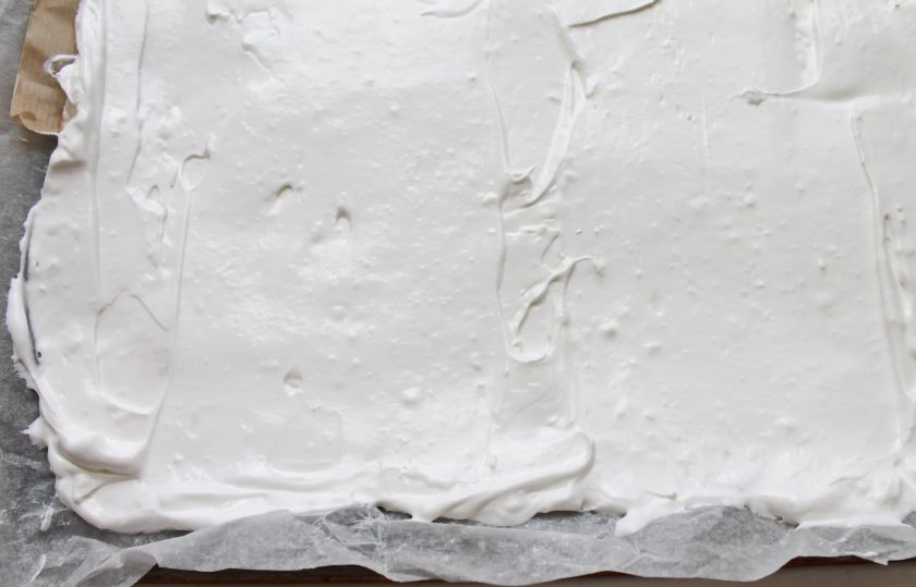 1. Этап. Меренговый рулет с клюквой: Противень 30*25 застелите пергаментом и разложите тесто ровным слоем.