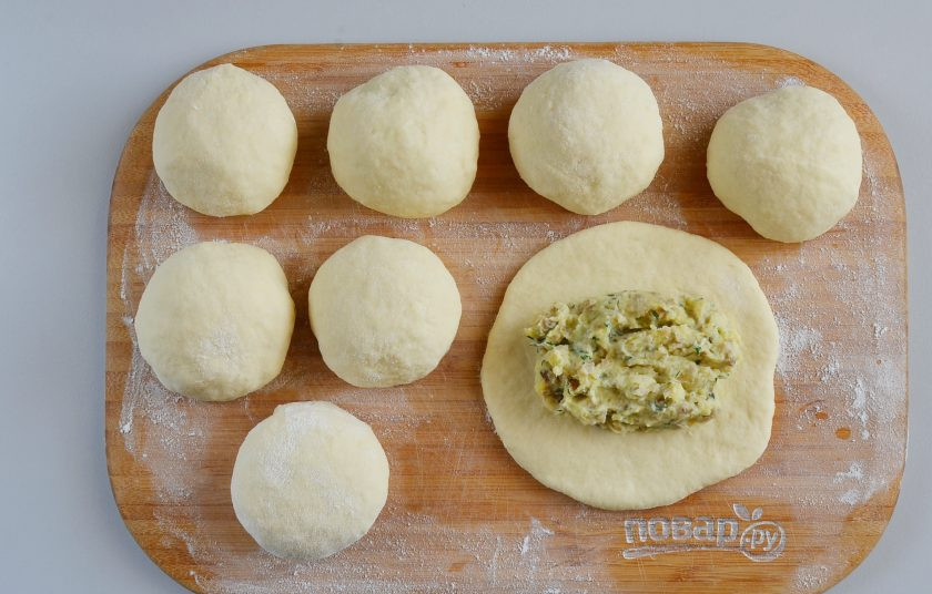 1. Этап. Вкусные пирожки на кефире: Каждый комочек теста раскатайте скалкой в небольшой круг. Выложите 2-3 ложки столовых начинки.