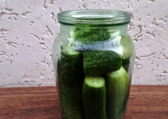 1. Этап. Огурчики с кетчупом на зиму: На дно банки выложите лист хрена, укроп, петрушку, специи, зелень и небольшой кусочек острого перца. Затем плотно выложите огурцы, можете их порезать, если у вас крупные овощи.