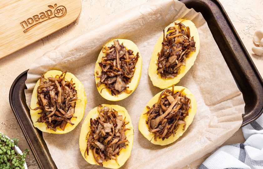 1. Этап. Картофель фаршированный вешенками: Переложите картофель на застеленный пергаментом противень. Запекайте в разогретой до 180 градусов духовке 15 минут.