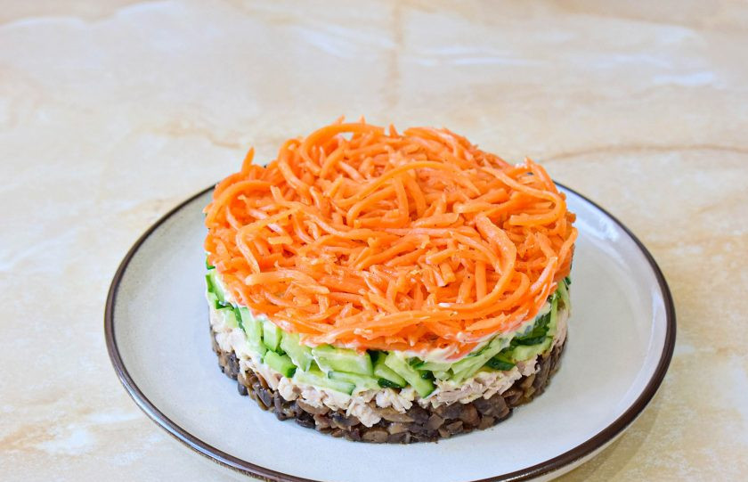 1. Этап. Салат Восторг с корейской морковью: Верхним слоем выложите морковь по-корейски. Немного прижмите, чтобы слои стали плотнее друг к другу и снимите сервировочное кольцо.