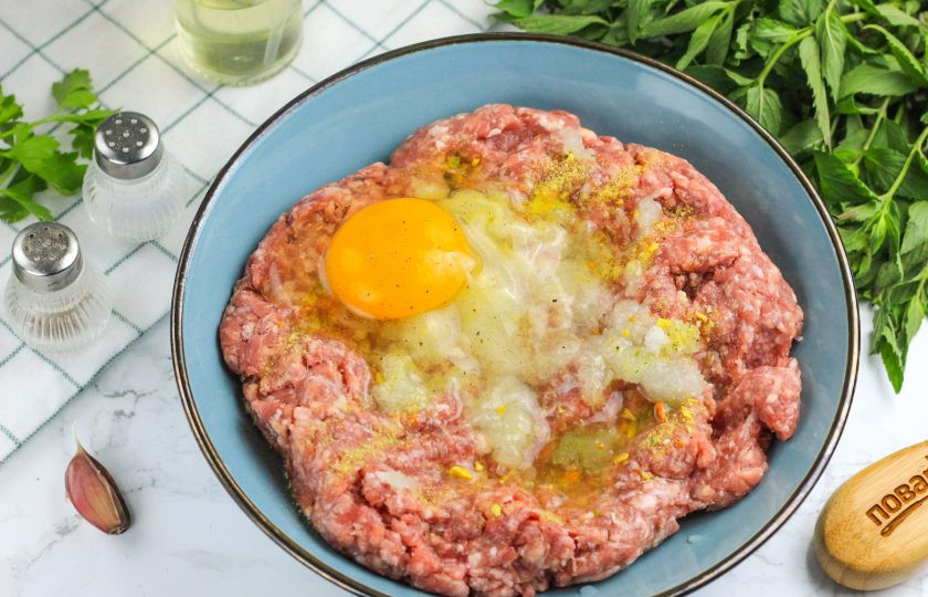 1. Этап. Чевапчичи в аэрогриле: Вбейте куриное яйцо небольшого размера и тщательно вымешайте фарш. Отбейте его, беря в руку и кидая обратно в емкость. Таким образом из фарша выбьются пузырьки воздуха.