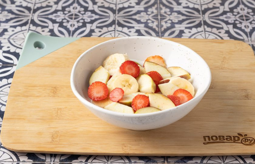 1. Этап. Фруктово-ягодный салат с йогуртом: Добавьте в миску яблоко, банан и клубнику.
