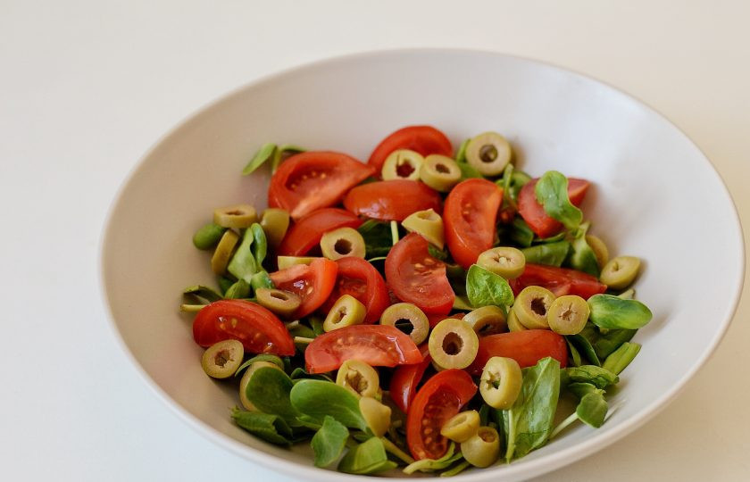 1. Этап. Салат с брюссельской капустой и помидорами: Помидоры нарежьте четвертинками, а оливки колечками.