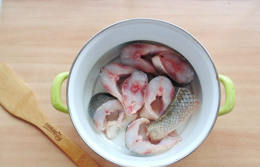 1. Этап. Заливное из пеленгаса: Выложите нарезанную рыбу в широкую кастрюлю.