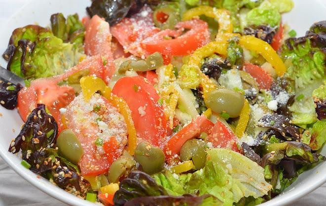 1. Этап. Салат с лимонной заправкой: Выкладываем в салатницу кунжут и оливки, смешиваем с нашей лимонной заправкой, посыпаем сверху тертым пармезаном - и салат готов!