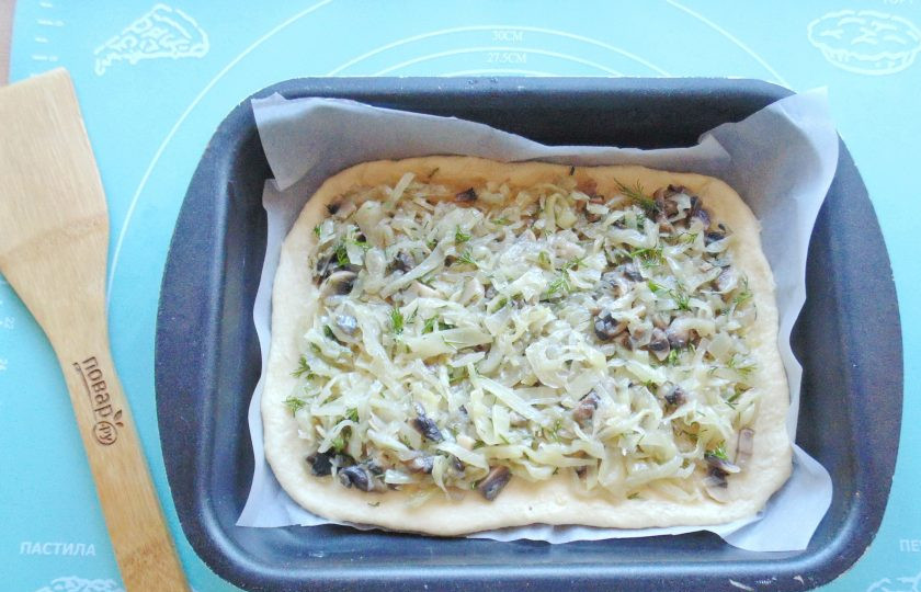 1. Этап. Пирог с капустой и грибами: Выложите пласт теста в форму для выпечки. Разложите на нем начинку.