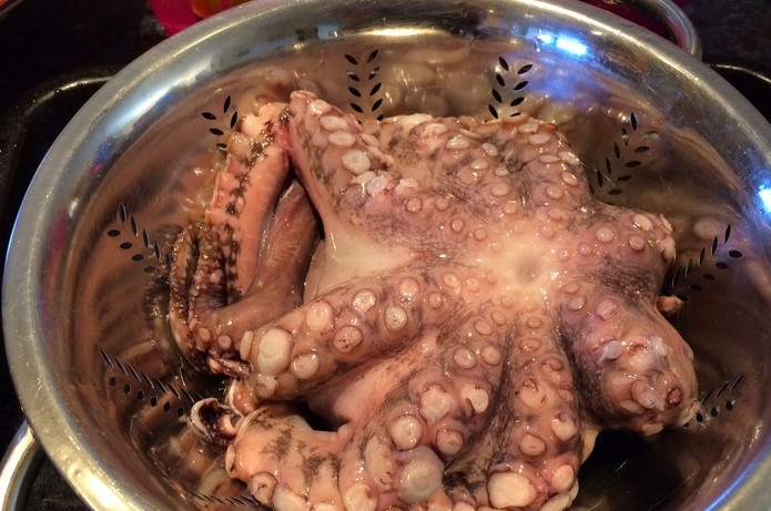 1. Этап. Осьминоги в вине: Промываем и обсушиваем тушку осьминога. Присыпаем перцем по вкусу. Солить не стоит, мясо и так соленое.