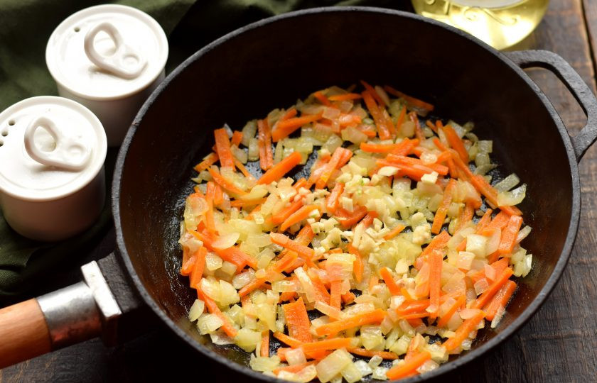 1. Этап. Гречка с кальмарами: С моркови счистите верхний слой, нарубите тонкими полосками, отправьте к луку. Овощи обжаривайте на среднем огне до мягкости около 5 минут, в конце добавьте рубленый чеснок.