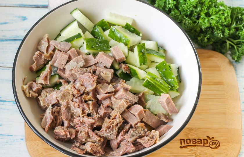 1. Этап. Салат из свиного языка с огурцом: Следом нарежьте брусочками или кубиками остывший и очищенный отварной свиной язык, добавляя нарезку к остальным ингредиентам.