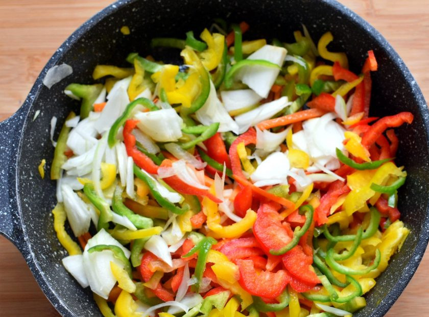 1. Этап. Острые пикантные цукини с овощами: Добавьте к моркови тонко нарезанный лук и перцы. Прогрейте при помешивании минутку-другую до появления яркого аромата.