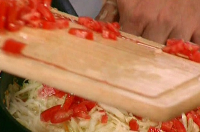 1. Этап. Капуста, тушеная с рыбой: 4. Как только капуста начнет становится более мягкой и пускать сок, отправляем к ней нарезанный помидор (кусочками среднего размера), перемешиваем и жарим около 3 минут.