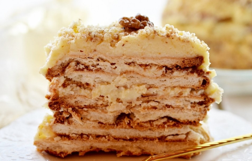 1. Этап. Простое слоёное пирожное: После того, как пирожное спрессовалось, смажьте кремом верхний слой и бока, посыпьте измельчёнными орехами и снова поместите на холод для пропитки.