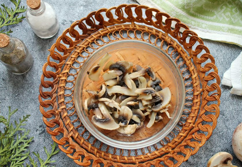 1. Этап. Салат Гречанка: Шампиньоны порежьте и отварите в соленой воде на среднем огне до готовности. Откиньте их на сито, дайте отвару полностью стечь и остудите.