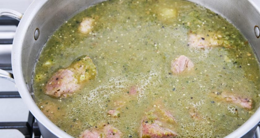 1. Этап. Свинина в зеленом соусе: 6. Влейте бульон в кастрюлю с мясом и добавьте измельченную в блендере смесь перцев с овощным физалисом. Если на дне кастрюли остались пригоревшие корочки с мяса, то соскребите их и все перемешайте. Добавьте в бульон мед, корицу, тмин, орегано и соль по вкусу. Доведите до кипения, уменьшите огонь и готовьте 2,5 часа.