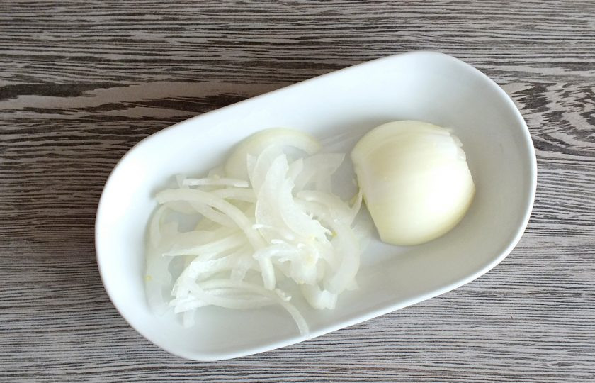 1. Этап. Пикша в духовке под сыром: Луковицу очистите и нарежьте тонкими полукольцами.