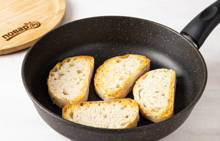 1. Этап. Бутерброды с хумусом: Нарежьте хлеб на ломтики средней толщины. Обжарьте их в сухой сковороде с двух сторон до румяности.
