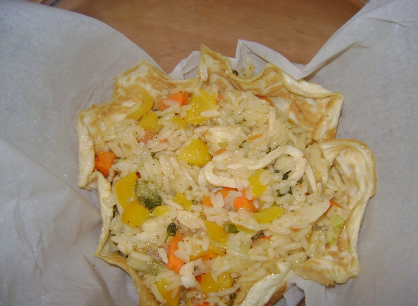 1. Этап. рис с овощами и морепродуктами: Яйца подсолить и взбить миксером. Испечь два омлета. Для подачи риса можно использовать и блины. В глубокую миску положить бумагу для запекания, омлет, а на омлет рис с овощами