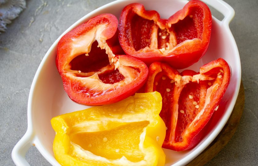 1. Этап. Перец фаршированный рисом и сыром: Перец помойте и обсушите. Разрежьте пополам и очистите от семян. Выложите их в форму для запекания.