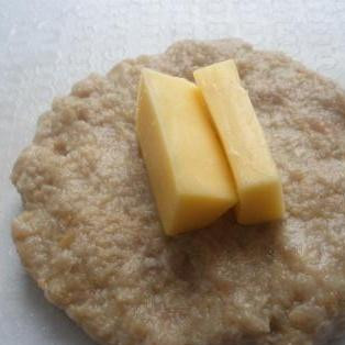 1. Этап. Котлеты с сырной начинкой: 3. Разделить фарш на небольшие кусочки. Сформовать из них лепешки и положить на них один или два кусочка сыра.