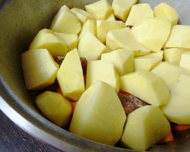 1. Stage. Tzimes with lamb: Coarsely chop the potatoes and lay them on top of the meat. Salt.