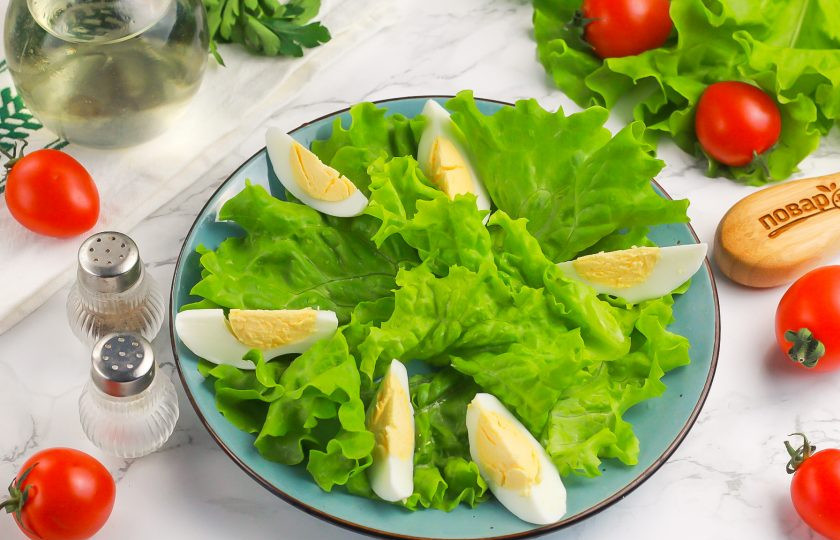 1. Этап. Салат с копченой треской и авокадо: Очистите куриные яйца от скорлупы и промойте в воде. Нарежьте на четвертинки и выложите между листьев салата на тарелку.