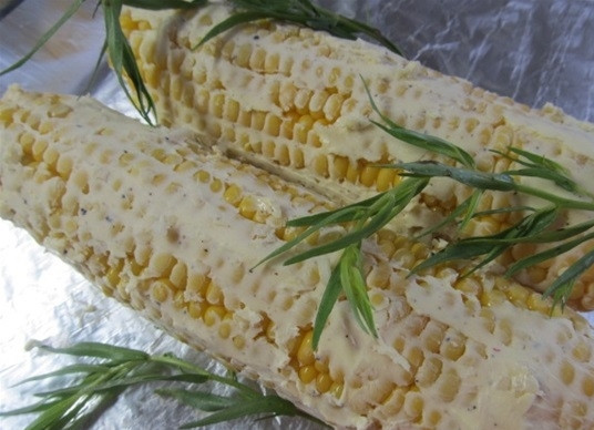 1. Этап. Кукуруза, запеченная в фольге с чесноком: Полученной смесью хорошенько натрите очищенные, промытые кукурузные початки. Добавьте разделенный на мелкие веточки эстрагон, он придаст особый аромат и пикантный привкус.