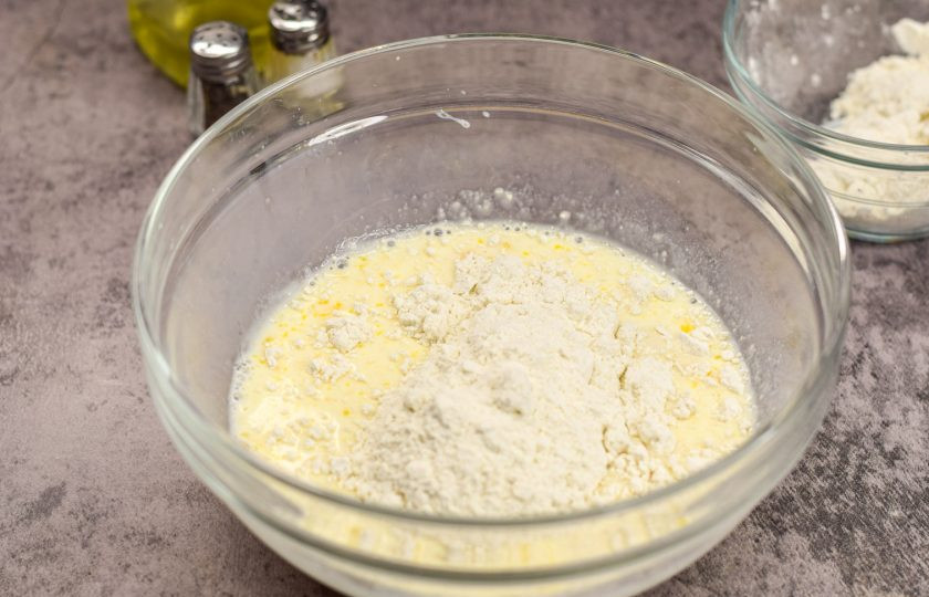 1. Этап. Блины из сырого картофеля: Следом добавьте пшеничную муку, еще раз все тщательно перемешайте, чтобы не было комочков. Влейте кипяток и снова все перемешайте.