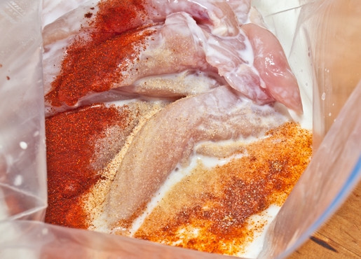 1. Этап. Куриное филе во фритюре: Для начала сделайте маринад. Сливки перемешайте с кайенским перцем, чесночным порошком, солью, паприкой и перцем. Перемешайте кусочки филе с маринадом. Уберите в холодильник на 30 минут.