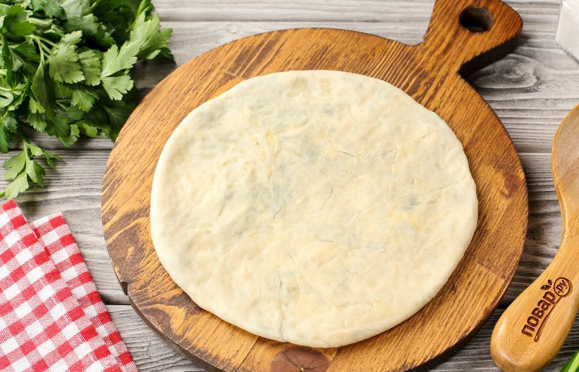 1. Этап. Заварные лепёшки с сыром и зеленью: Затем переверните, немного придавите тесто с начинкой ладошкой и раскатайте аккуратно, чтобы тесто не порвалось. Если будут образовываться пузыри, можно проколоть их для выхода воздуха зубчисткой. Чем тоньше получится раскатать, тем лучше.