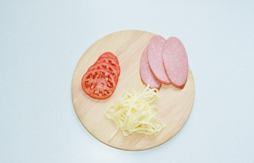 1. Этап. Пицца с сосисками по краям: Нарежьте тонко помидоры, сыр натрите на терке. В начинку я решила добавить дополнительно несколько ломтиков колбаски.