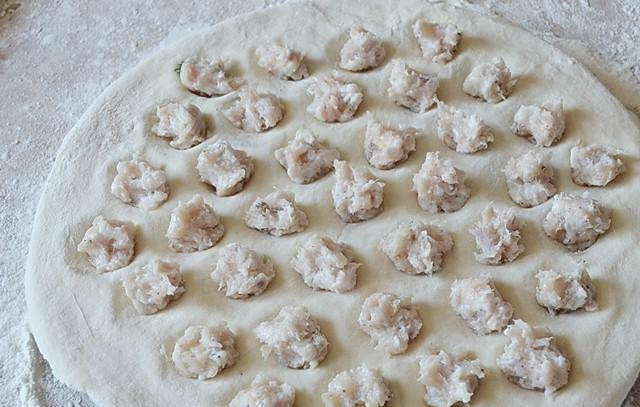 1. Этап. Пельмени куриные: В каждую лунку выложите неполную чайную ложку фарша.