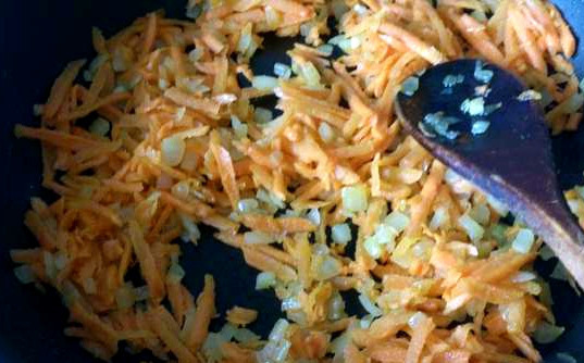 1. Этап. Фасоль со щавелем: Пока варится бульон, подготовим овощи. Почистим картошку, морковь и лук. Нарезанный картофель пока отложим в холодную воду. Натрем морковь и нарубим лучок. Обжарим морковь с луком на сковороде, добавив подсолнечного масла.