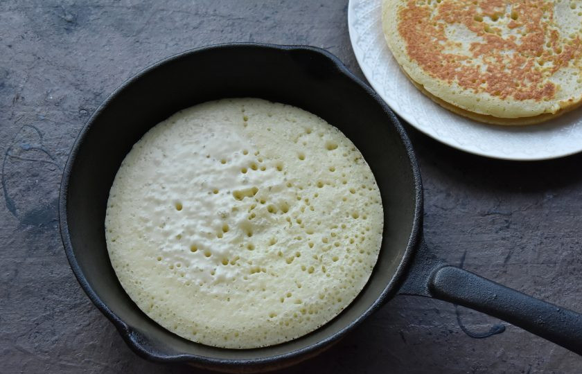 1. Этап. Пышные панкейки рецепт на кефире: Сковороду с толстым дном и желательно антипригарным покрытием разогрейте на среднем огне. Влейте тесто. Количество теста зависит от желаемого размера панкейкков. Обжарьте панкейк с одной стороны до подрумянивания.