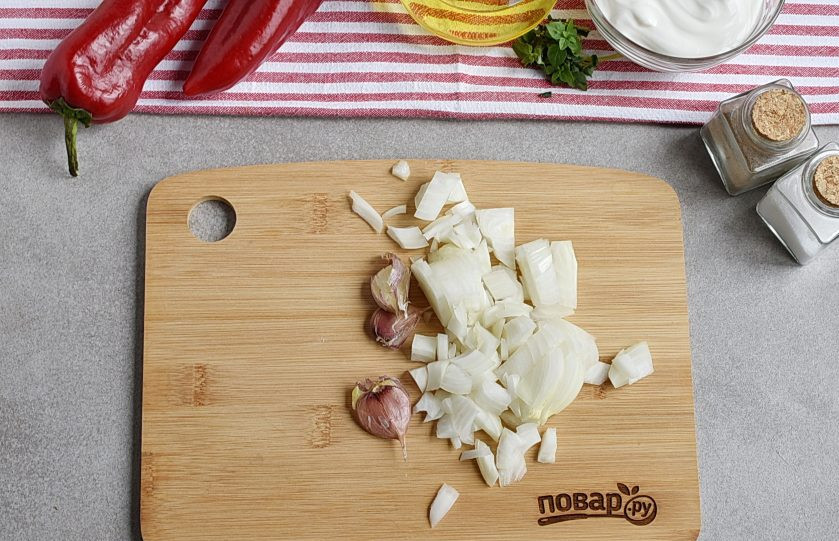 1. Этап. Вкусный соус к макаронам: Лук нашинкуйте кубиками, чеснок приплюсните ножом.