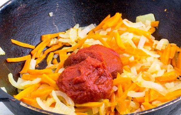 1. Этап. Кабачковая икра с морковкой: 7. К моркови с луком добавьте немного томатной пасты и чуточку воды. Тушите еще пару минут, а затем переложите к кабачкам и на среднем огне протушите все вместе еще минут 10.