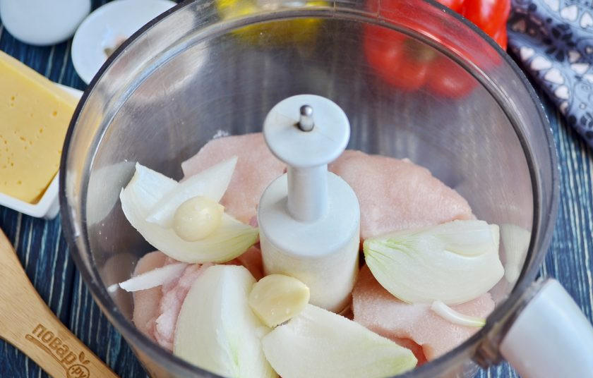1. Этап. Котлеты из курицы с паприкой: Вымойте куриное филе, для котлет достаточно двух крупных половинок грудки, порежьте их на крупные кусочки, положите в чашу измельчителя. Добавьте очищенный лук и чеснок, соль. Измельчите. Можно воспользоваться мясорубкой.