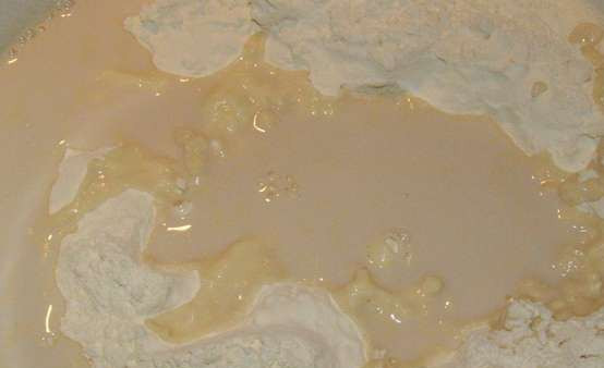 1. Этап. Пирог Брилья-Саварен: Просеиваем муку в миску. Делаем по центру углубление и вливаем теплое молоко с разведенными в нем дрожжами, также добавляем взбитые яйца.