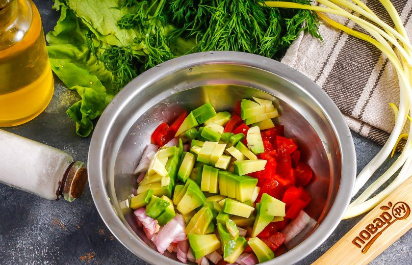 1. Этап. Начинки для мексиканских лепешек: Половинку авокадо очистите от кожуры, нарежьте мелкими кубиками. Точно так же поступите и с помидорами черри, промыв их предварительно в воде. Очистите красный лук, промойте и измельчите. Соедините все нарезки в глубокой емкости, посолите и заправьте растительным маслом, аккуратно перемешайте.