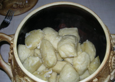 1. Этап. Галушки на кефире: 7. Несколько галушек выложить в горшочек и добавить сливочное масло, затем опять слой галушек и масла. Сверху можно добавить сметану с чесноком, отварную курицу, жареные грибы с луком или влить бульон, например. Также можно использовать томатный соус. Отправить галушки в разогретую духовку на 3-5 минут, чтобы они пропитались маслом и ароматом заправки, а затем сразу подавать к столу.