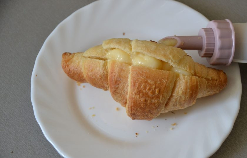 1. Этап. Круассаны с заварным кремом: Переложите заварной крем в кондитерский мешок и начините кремом круассаны.