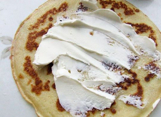 1. Этап. Блинчики с икрой красной: 4. После приготовления блинчики нужно немного остудить. Мягкий сыр тонким слоем намазать на блинчик. При желании его можно дополнить измельченной свежей зеленью.